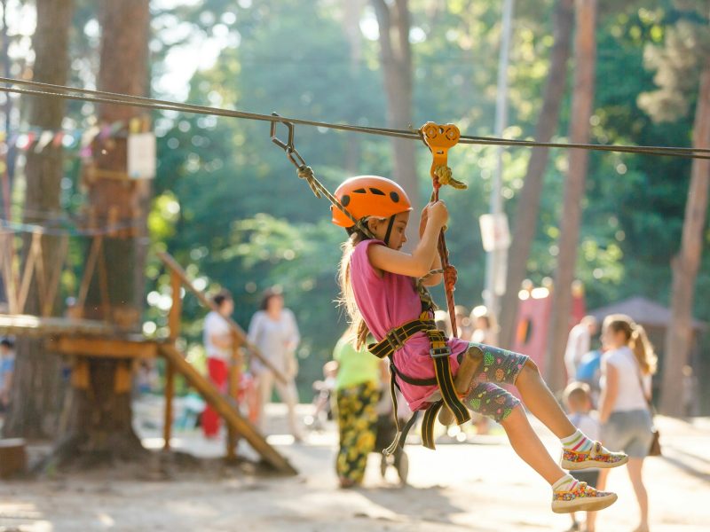 Smiling little girl on the playground, climbing rope net